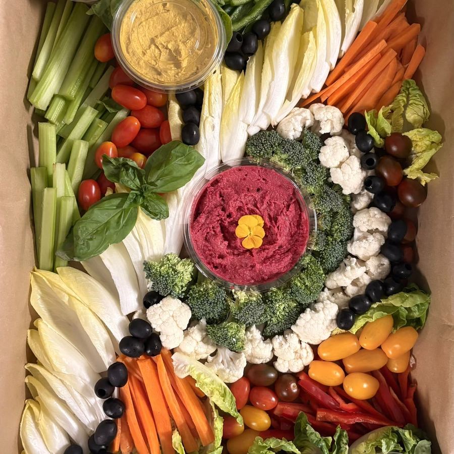 A crudités platter of raw vegetables arranged around a dip.