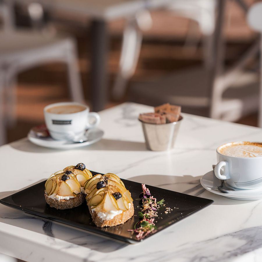 A marble table set with coffee and pastries.