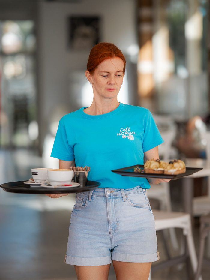A server setting down a coffee.
